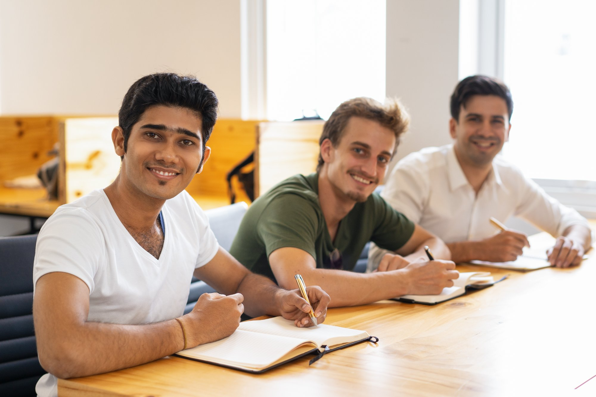 Multiethnic group of happy students posing in classroom
